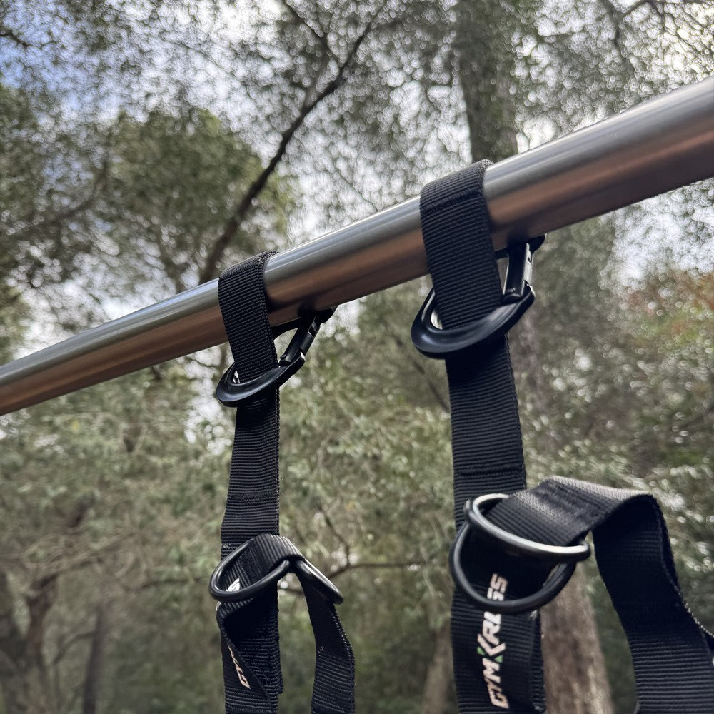 Gros plan sur les sangles de suspension GymKross fixées solidement à une barre en métal, garantissant une sécurité et une stabilité maximales pour des entraînements en suspension en extérieur.