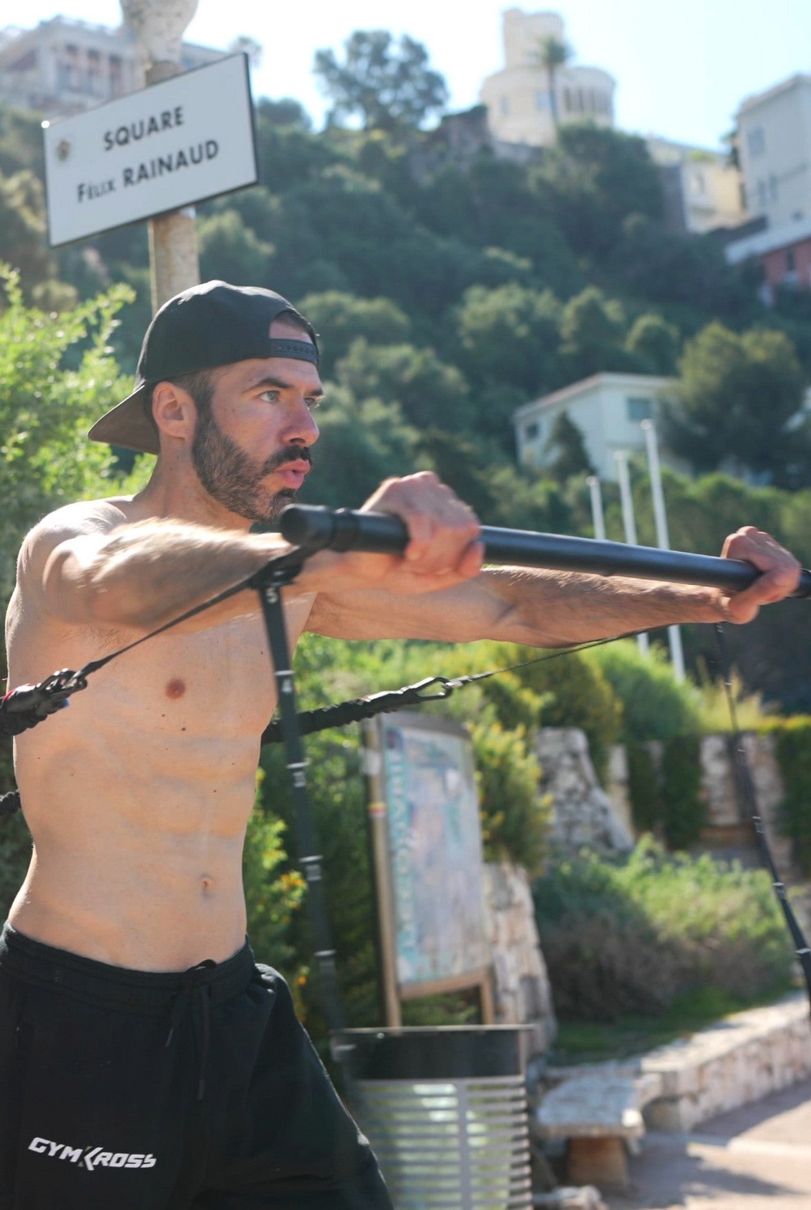 Un homme effectuant un exercice de chest press avec des bandes de résistance GymKross, dans un Square.