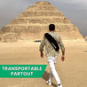 Explorateur portant un sac Gymkross devant la pyramide à degrés de Djoser à Saqqarah, Égypte, symbolisant la fusion de l'histoire ancienne et du fitness moderne.
